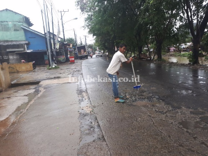 Hindari Kecelakaan, Kuras Air di Jalan Berlubang