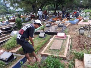 Seorang Siswa Mengisi Liburan Dengan Bersih-Bersih Makam