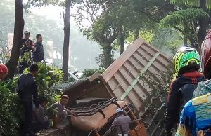 Diduga Supir Mengantuk, Truk Muatan Batu Terjungkal di Saluran Air Summarecon