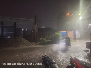 Bekasi Diguyur Hujan Disertai Angin Kencang, Pengendara Motor Menepi di Sepanjang Emperan Toko