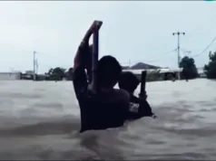 Di Tengah Arus Banjir, Warga Sukamekar Gendong Televisi ke Tempat Aman