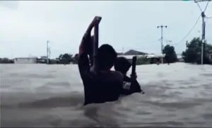 Di Tengah Arus Banjir, Warga Sukamekar Gendong Televisi ke Tempat Aman