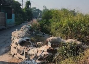 Jalan Penghubung Tambun Utara-Sukawangi Menyempit Akibat Tumpukan Karung